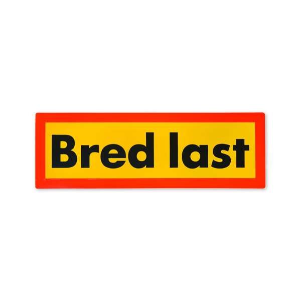 Rechteckige „Bred last“-Tafel in Gelb mit rotem Rand und schwarzer Schrift.