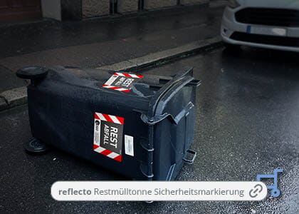  overturned residual waste bin on the street with reflecto safety markings in the rain