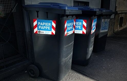 Papiertonnen auf dem Gehweg mit reflecto Sicherheitsmarkierungen bei Nacht